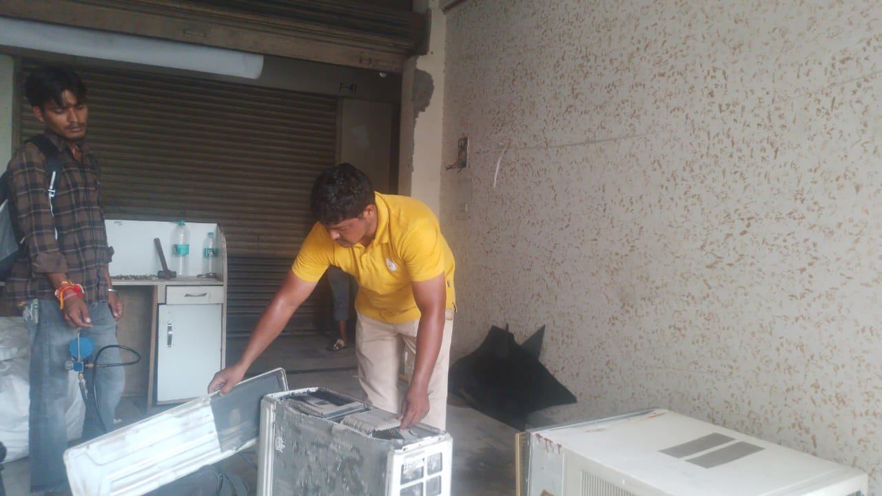 Freshwind AC Service technicians servicing an AC unit outside the shop